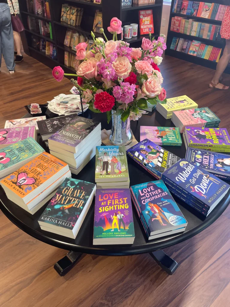 table dans une librairie avec divers livres de romance et fantasy posé dessus